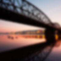Amazing sunrise in the city. Railway bridge (with reflection in the river) and embankment in Prague, Czech Republic.